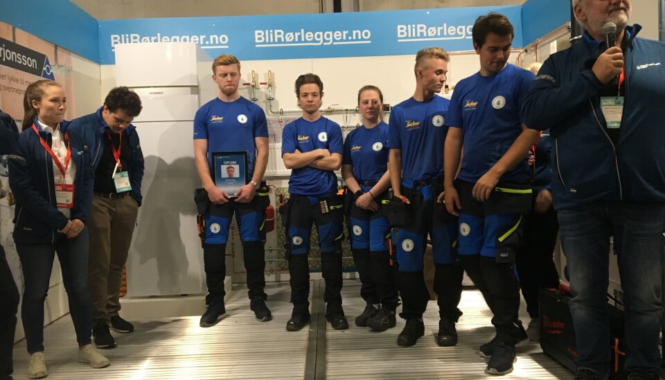 Erlend Haug midt i bildet med diplom og de andre finalistene ved siden av seg. Hoveddommer Helge Andersen til høyre med mikrofon.