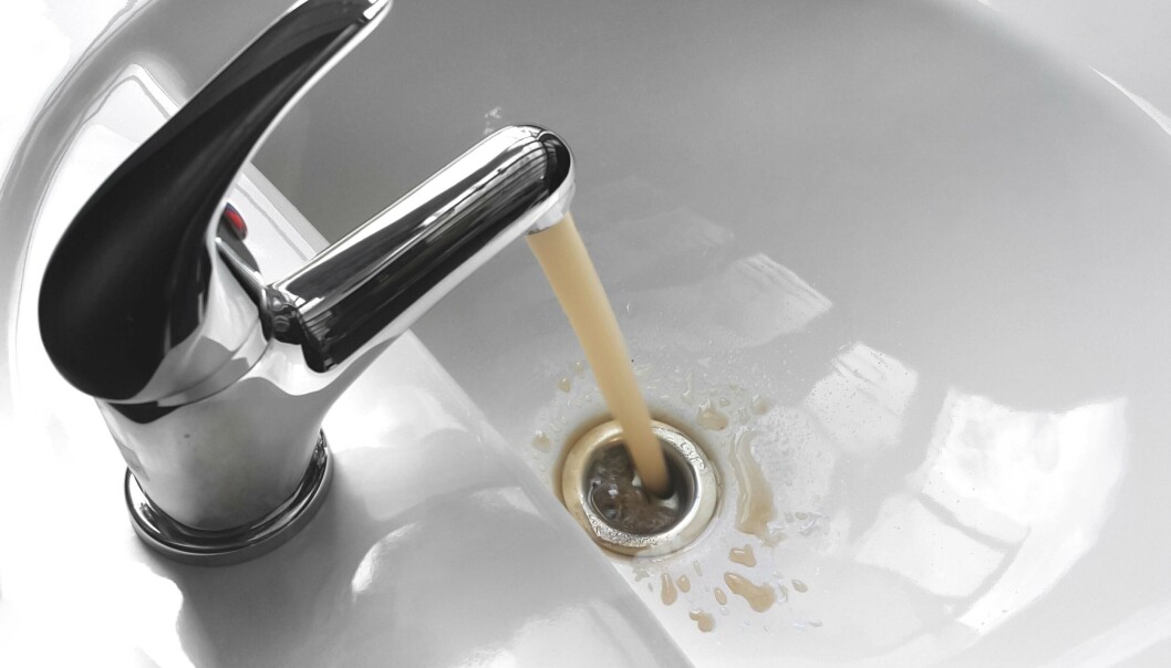 Water tap faucet with flowing contaminated muddy and dirty water in a white bathroom sink. Water tap faucet with flowing contaminated muddy and dirty water in a white bathroom sink.