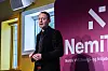 Person holder presentasjon foran Nemitek-banner i konferansesal.