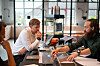 Designworkshop med tre personer, prototyper og materialprøver på bordet.